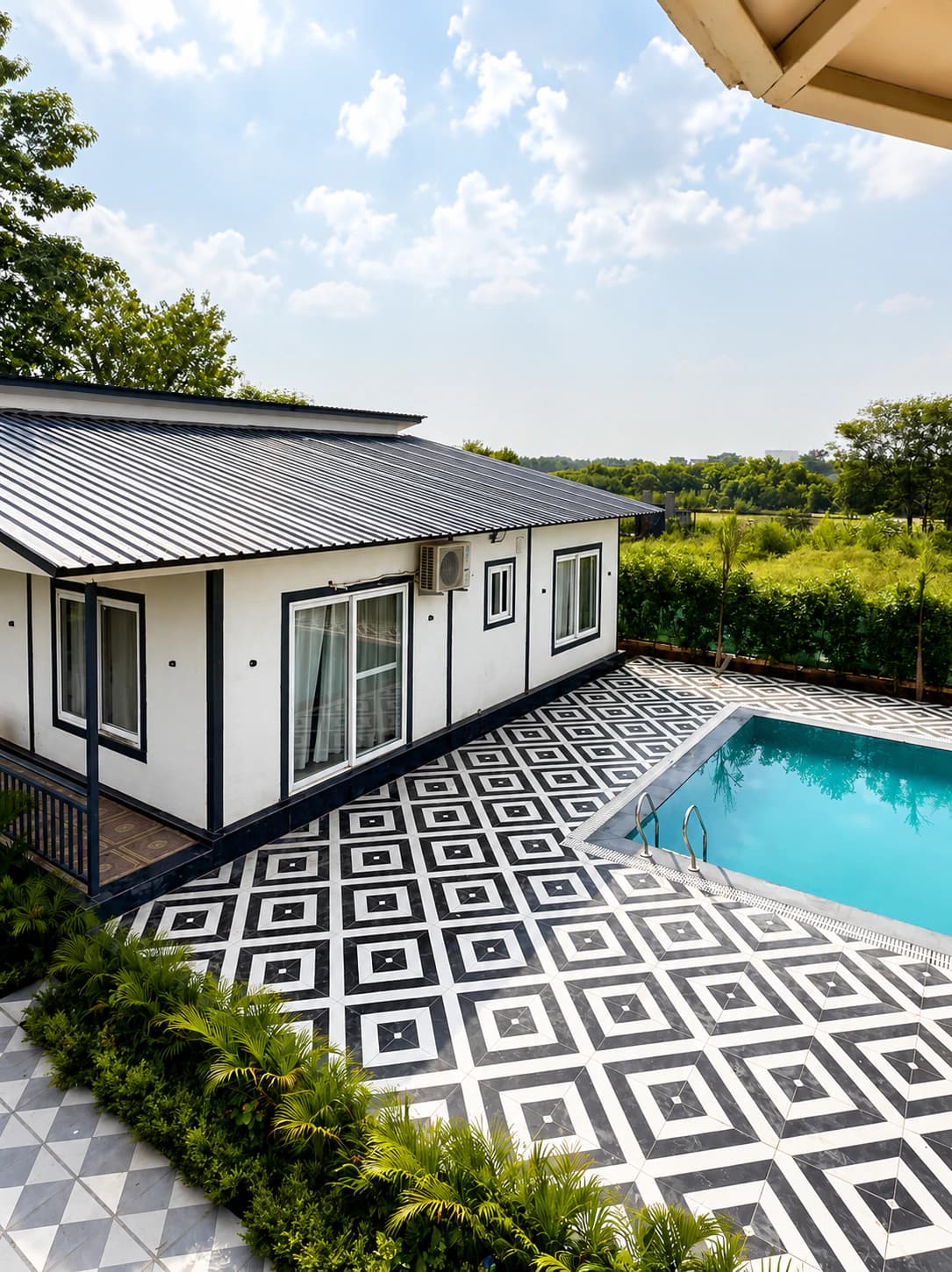 Elevated view of the geometric poolside deck, turquoise pool and hedged garden edge